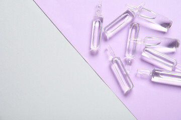 Glass ampules on color background