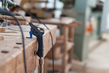 Air duster lying on workbench in a carpenter's workshop