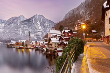 Winter sunset view of Hallstatt village with snowy mountains and traditional houses, Austria