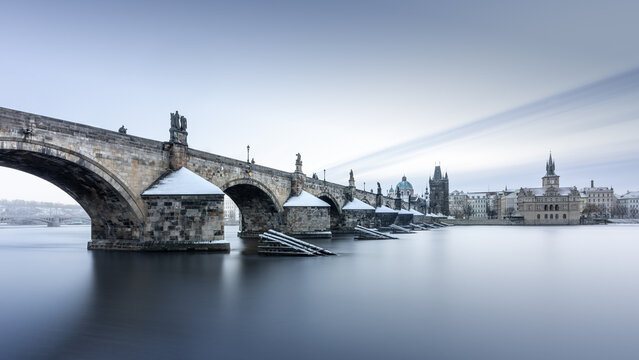Long exposure of the snow-covered, historic Charles Bridge on the Vltava River in Prague, Czech Republic, Europe
