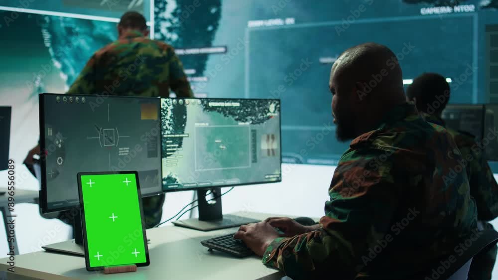 Poster soldier gathering real time surveillance data next to mockup display in high tech command center, pr