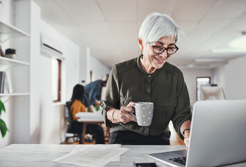Mature, businesswoman and typing on laptop in office for editing blog post, online article or...