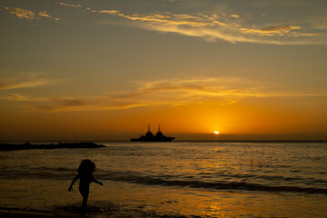 Fototapeta premium silueta de niña corriendo en la playa atardecer