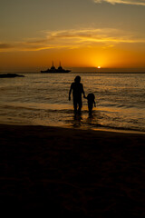 madre e hija silueta jugando en la playa