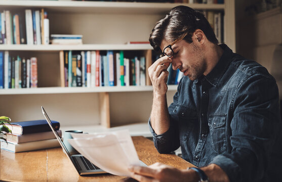 Documents, stress and man with laptop in home with struggle for job application online. Frustration, resume and person with computer for rejection email with cv vacancy for unemployment in apartment.