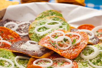 Close-up of central section of a natural fiber basket or basket containing a group of various toasts covered with different sauces of exotic flavors.