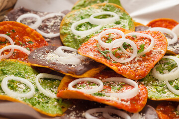Closed plan of a natural fiber basket containing a group of various toasts covered with different sauces with exotic flavors.