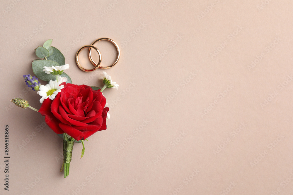 Sticker Small stylish boutonniere and rings on beige background, top view. Space for text