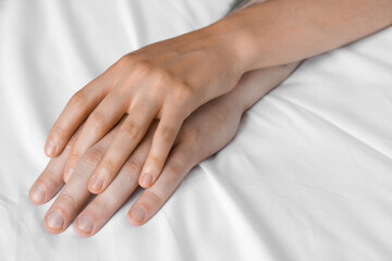 Lovely couple holding hands in bed, closeup