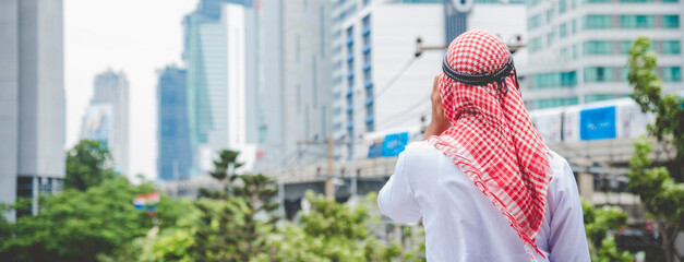 Backside Islamic man wear formal muslim dress in modern uae city. Arab men traditional hijab...