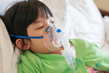 Sick little asian girl inhalation with nebulizer for respiratory treatment