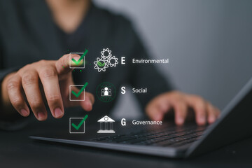 ESG environmental social governance strategy investment business concept. Businessman checking mark on checklist with checkmark on virtual screen. Sustainable and Ethical organization development.