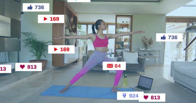 Image of social media notifications over biracial woman practicing yoga at home - Powered by Adobe