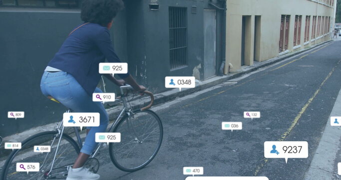 Image of media notifications over african american woman on bike in city street