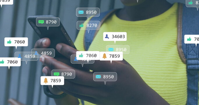 Image of social media notifications over happy african american woman using smartphone in city