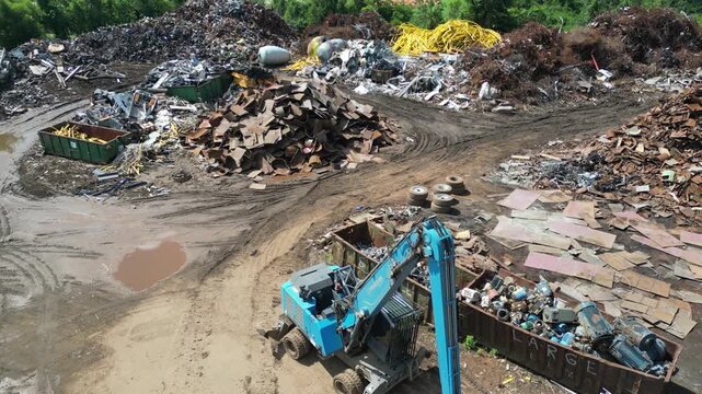 pushing drone view of scrapyard to baseball field and park on a bright sunny day