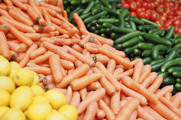 Fresh Market Produce Beautiful assortment of colorful Carrots, Lemons, Cucumbers, and Tomatoes