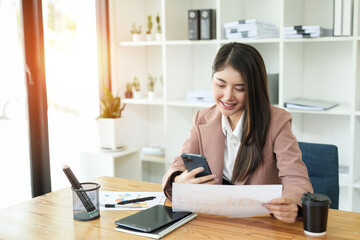 Asian business woman Use a laptop computer and work at the office ready. plan to analyze financial reports