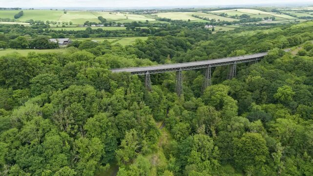 Aerial view of holiday tourists crossing over the Meldon Viaduct enjoying the scenic landscape of Devon, England