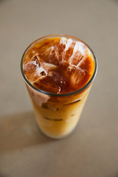 Glass of iced coffee over a concrete table.