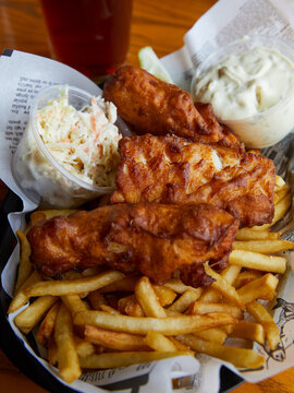 Fish and chips with coleslaw and tartar sauce.