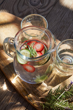 Carafe of water wit fresh strawberries, cucumber and rosamary.