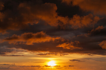 Fototapeta premium Dramatic sunset sky covered with colorful yellow clouds. Panoramic skyscape