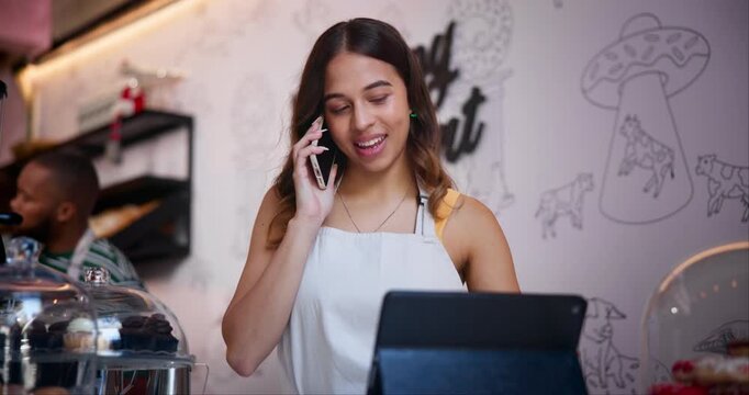 Cafe, woman and talking with tablet in phone call for online order in small business for easy food delivery or takeaway. Virtual, cashier and barista with communication of services in coffee shop