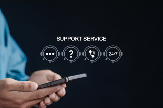 24-7 customer service support concept, customer help center. Businessman using smartphone with support service icons on virtual screen.