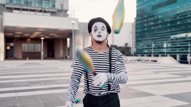 Juggling, mime and man in city for circus, entertainment and creative act in urban town. Street performer, theatre and person with pins juggle for festival, carnival and performance in costume