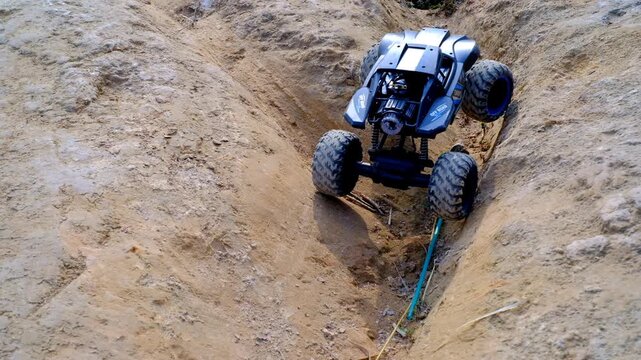Footage Rock Crawler Remote Control Car climbing a mound of earth. Playing Rc toys outdoor in the morning. Graphic Resources. 4x4 RC car. Hobby and leisures. 4K Videography 30 Fps