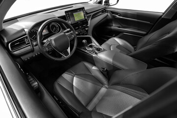 Interior of new modern SUV car with steering wheel, shift lever and dashboard, climate control,...