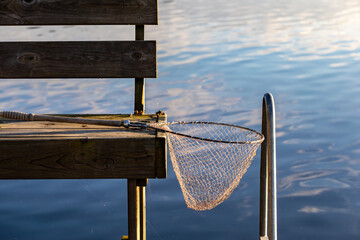 Stockholm, Sweden A small handheld fishing net resting on a dock in summer.