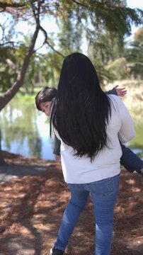 Mexican mother playing around with her son at the park mothers day concept