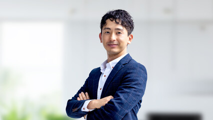 腕組みをする笑顔の日本人男性ビジネスマン