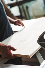 Carpenter checking wood plank quality in his workshop