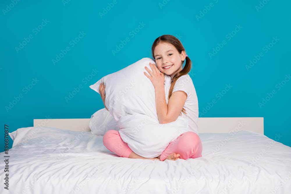 Sticker Full body photo of cute little girl hugging pillow sit bed sleeping time dressed pajama isolated on blue color background