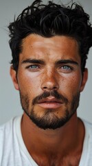 Fototapeta premium Close up view of a young man with a beard and striking blue eyes