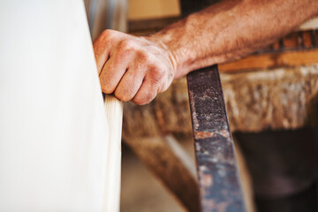 Carpenter using traditional tools working wood in workshop
