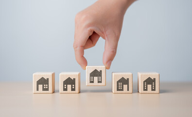 Real estate management, Property, Asset investment concept. Hand picking wooden cube block with...