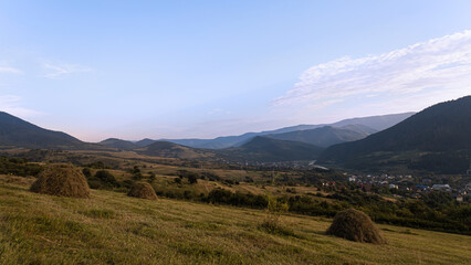 Mountain farmland landscape with haystacks