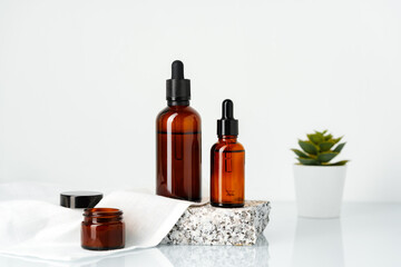 Amber Glass Bottles With Dropper Tops Displayed on a Stone Platform