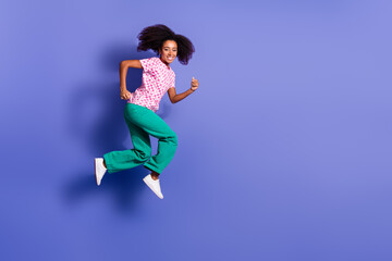 Fototapeta premium Full length photo of lovely young lady running hurry sales dressed stylish pink garment isolated on violet color background