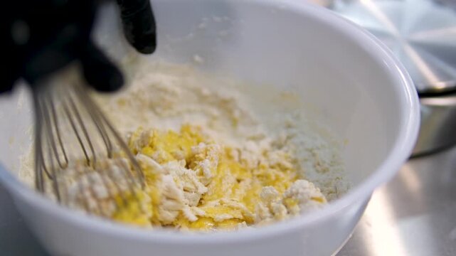 Whisk the dough. Woman prepares dough for pancakes. Mixing baking ingredients. Cooking, preparing breakfast, dessert