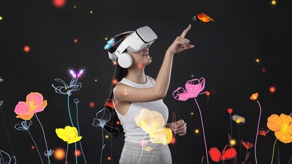 Beautiful Asian woman with VR glasses metaverse interacting with virtual neon flowers, trying to touch butterfly with new neon blossom in 3D pollen graphic floating meta garden world. Hallucination.