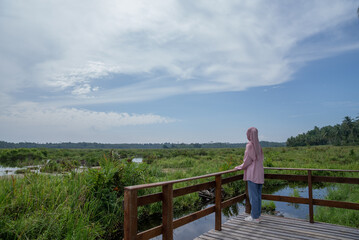 A woman enjoying the view of a large wetland or swamp in the morning
