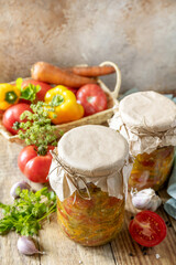 Healthy homemade fermented food. Salad tomatoes with vegetables on a rustic table. Home economics, autumn harvest preservation. Copy space.