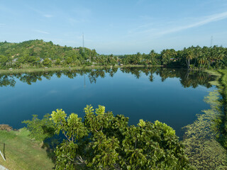 View of a large natural fish pond in Asia. View of a small, calm lake in Asia