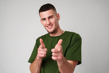 Young Man in Green T-Shirt Pointing With a Smile