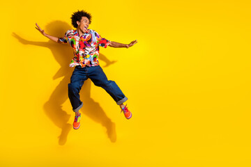 Full size photo of nice funky young man jump empty space wear shirt isolated on bright yellow color...